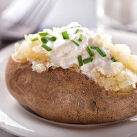 A delicious oven baked potato with sour cream and chives.