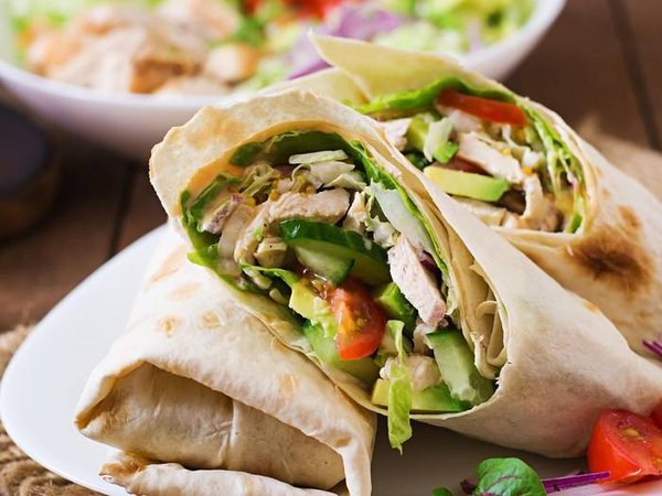 Fresh tortilla wraps with chicken and fresh vegetables on plate