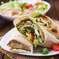 Fresh tortilla wraps with chicken and fresh vegetables on plate
