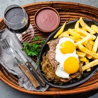 Peruvian Latin American food. Lomo a lo pobre. Beef tenderloin whit fried potatoes french fries and eggs