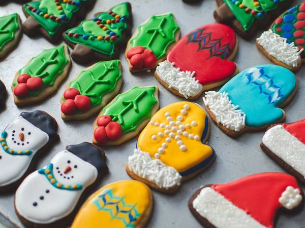 A variety of beautifully decorated Christmas sugar and gingerbread cookies on a baking sheet