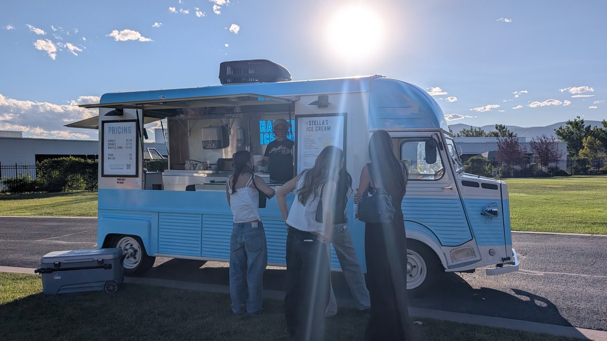 Stella's Ice Cream's pale blue vintage-style van serving customers at golden hour in Utah County
