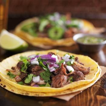 authentic mexican street tacos with barbacoa beef on yellow corn tortilla
