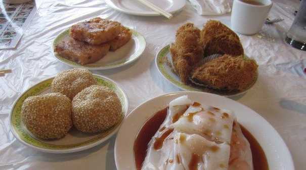 (Upper left and moving clockwise) Turnip cakes, taro puffs, shrimp wraps, and sesame balls